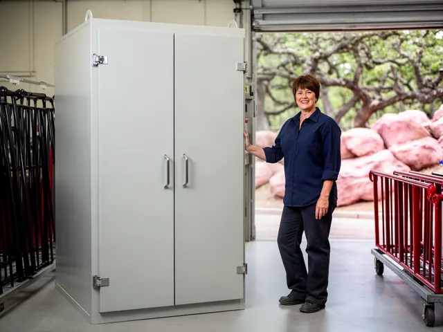 Metal finishing shop owner beside a new powder-coating oven